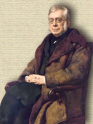 Portrait of Airy wearing wide lapel coat, seated diagonal to left in wooden chair with wicker side, 3/4 body facing forward