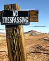 No Trepassing sign on rural barbed wire fencepost
