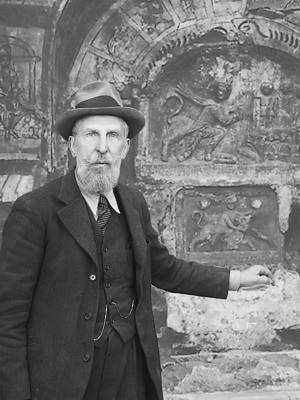 Photo montage of Franz Cumont standing in front of Mithraeum c.1933, upper body, wearing hat, facing front.