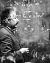 Photo Albert Einstein writing equations on a blackboard