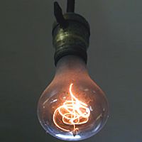 Photo of 1901 lightbulb still functioning with long spaghetti-like filament in glass globe of usual shape