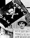 Photo of a protester with flag showing skull and crossbones to poison danger and lettering “Love canal”