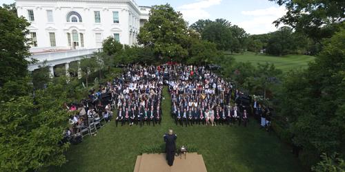 Photo, Aerial view White House Rose Garden Lawn with audience in rows of chairs, addressed from podium