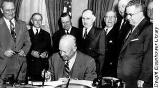 Photo of Officials watching President Einsenhower sign the Federal-Aid Highway Act of 1954. There is no photo for the 1956 Act.
