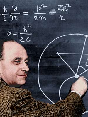 Photo of Enrico Fermi at blackboard diagram, upper body facing right. Colorization © todayinsci.com