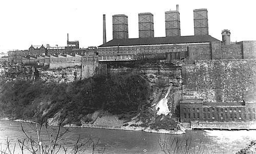 Photo of industrial buildings on top of tall steep cliff above Niagara gorge