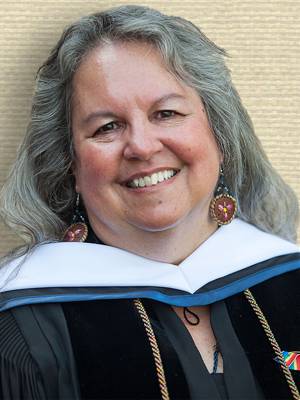 Photo of Robin Kimmerer, head and shoulders, facing forward, wearing academic gown