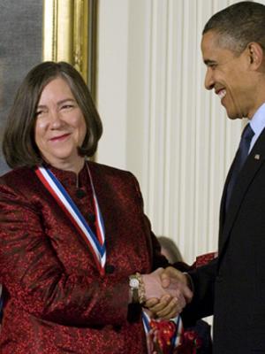 Photo of Susan Lindquist shaking hands facing forward receiving National Medal of Science from Pres Obama, standing, upper body
