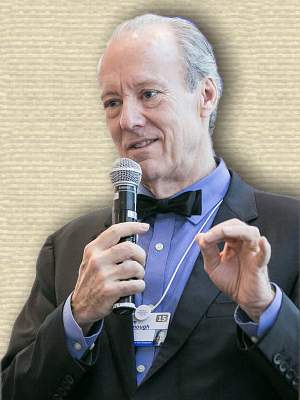 Photo of William McDonough, holding microphone, upper body