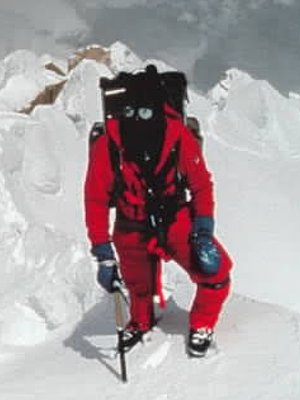 Book cover crop, All Fourteen 8,000ers, Reinhold Messner walking up steep snowfield, with backpack, ice axe, mask.
