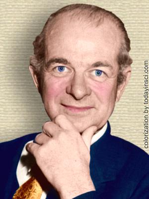 Photo of Linus Pauling, head and shoulders, hand on chin, facing forward. Colorization by todayinsci.com
