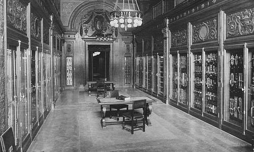 Photo of interior of Yale showroom, showing tall glass wall display cabinets in an elegantly decorated room with a chandelier